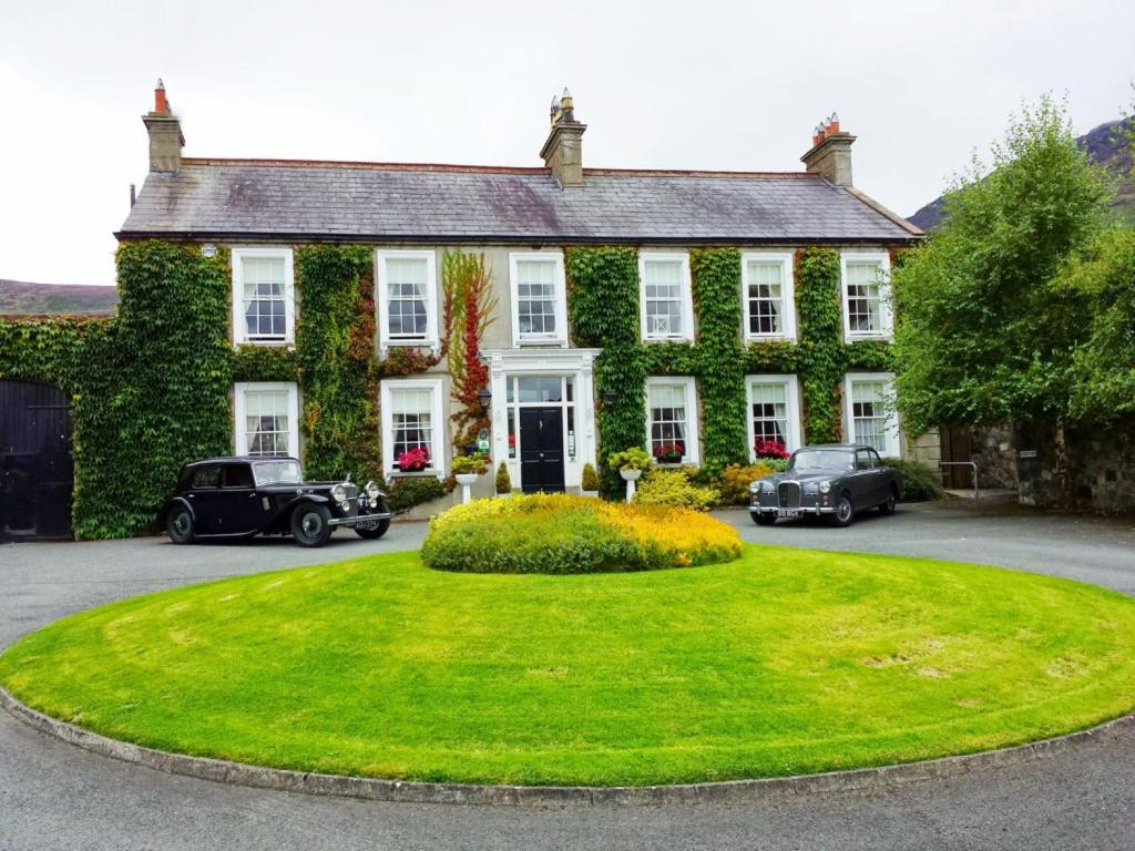 een groot huis met auto's geparkeerd voor het bij Carlingford House Town House Accommodation A91 TY06 in Carlingford