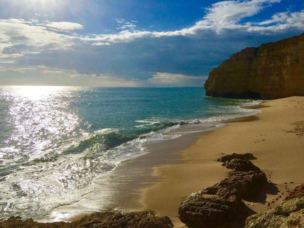 a beach with rocks and the ocean on a cloudy day at ColinaSol Vale Centeanes Appartement vue mer in Carvoeiro