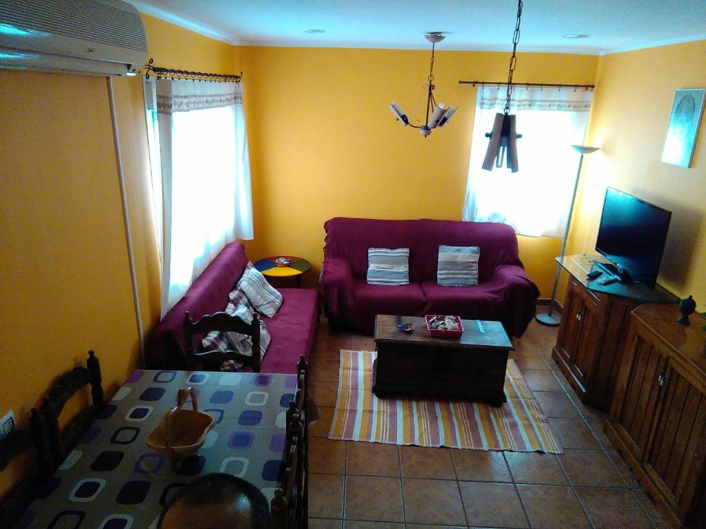 a living room with a red couch and a table at Bonito apartamento in Las Negras