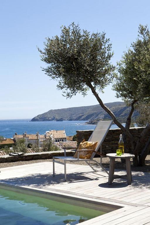 a pool with a chair and a table next to a tree at Casa Margot in Cadaqués