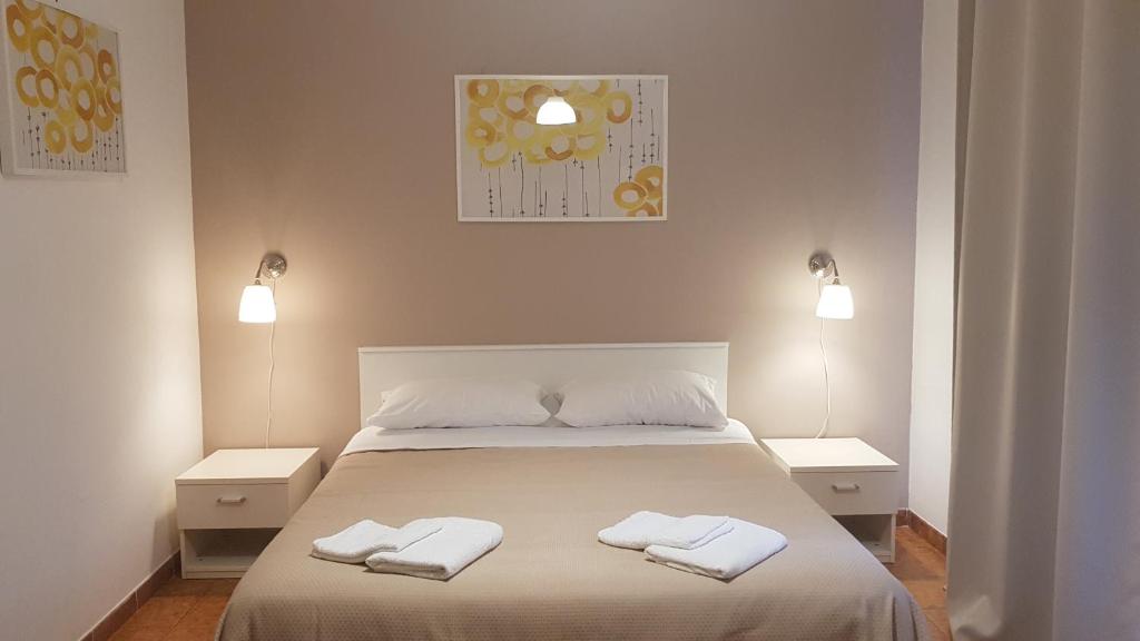 um quarto com uma cama com duas toalhas em B&B Mimosa em Giardini Naxos