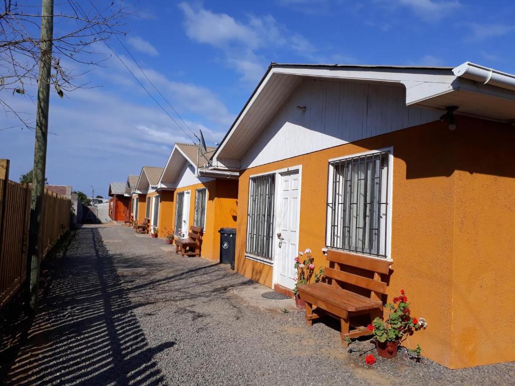 a row of houses with benches on a street at Cabañas Rupu Lafquén in Pichilemu