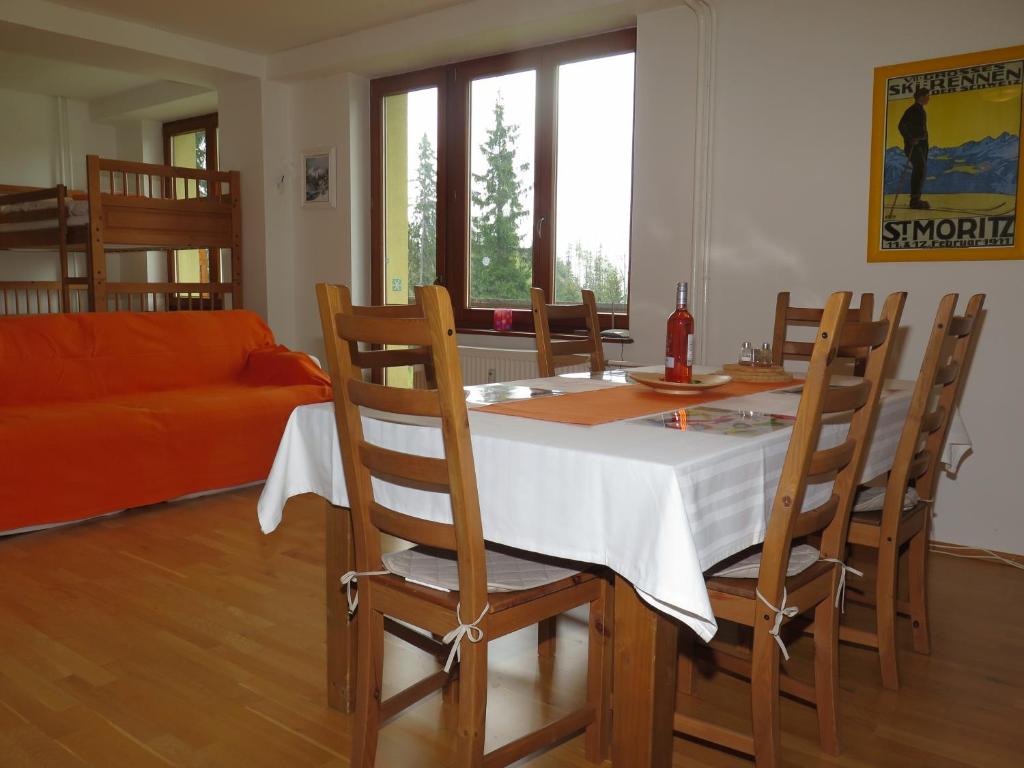 uma sala de jantar com uma mesa e cadeiras e um sofá em Apartmán Tuček em Štrbské Pleso
