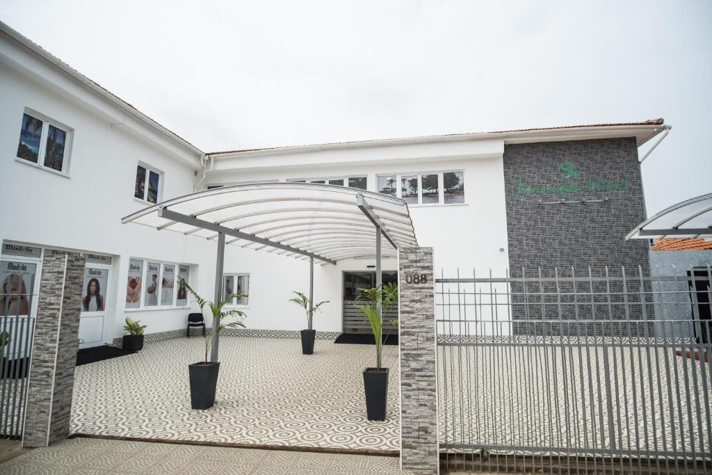 un bâtiment blanc avec des plantes en pot devant lui dans l'établissement SH Boutique Hotel, à São Tomé