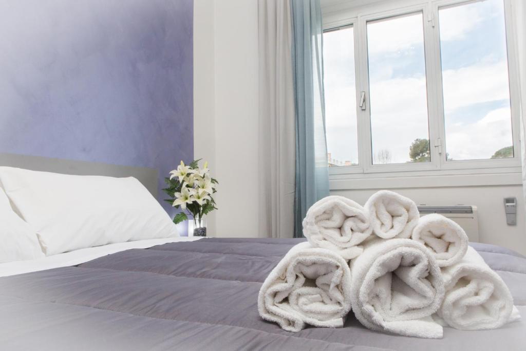 a bed with a pile of towels on it at Foresteria Boccadasse in Genoa