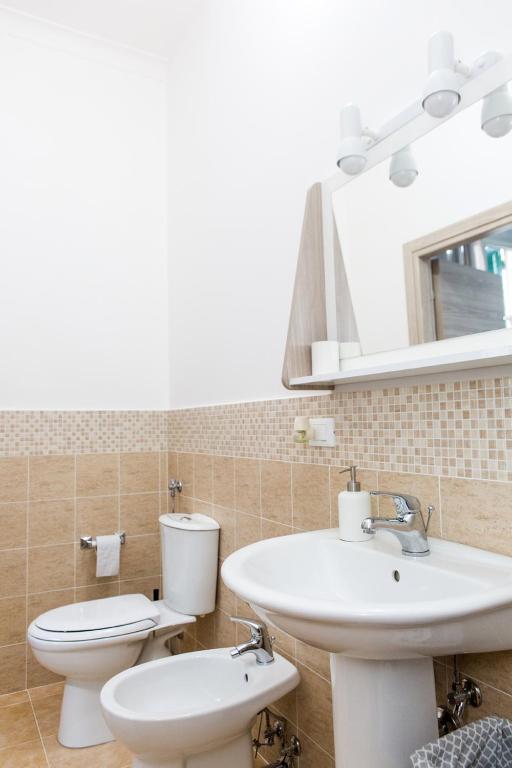 a bathroom with a sink and a toilet and a mirror at Foresteria Boccadasse in Genoa