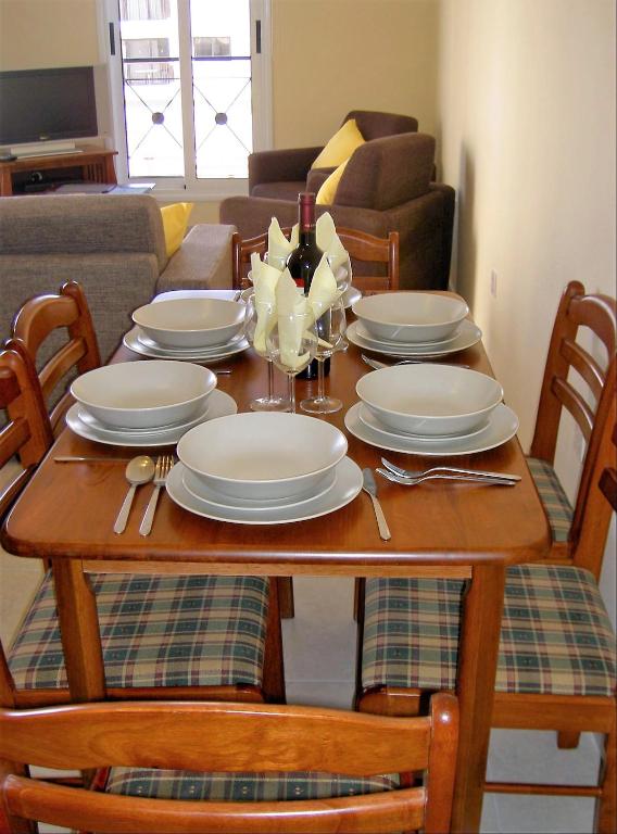 a dining room table with plates and wine glasses at Mazotos Panoramic Village in Mazotos