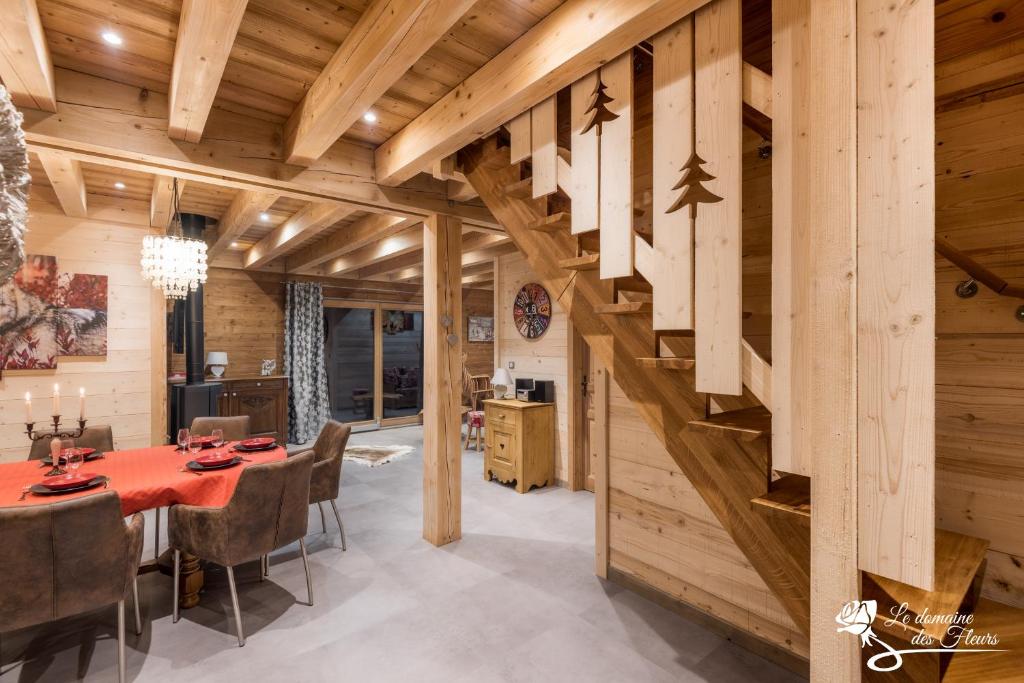 een eetkamer met een tafel en een trap bij Le Domaine des Fleurs - Chalet La Reine des Prés in Gérardmer