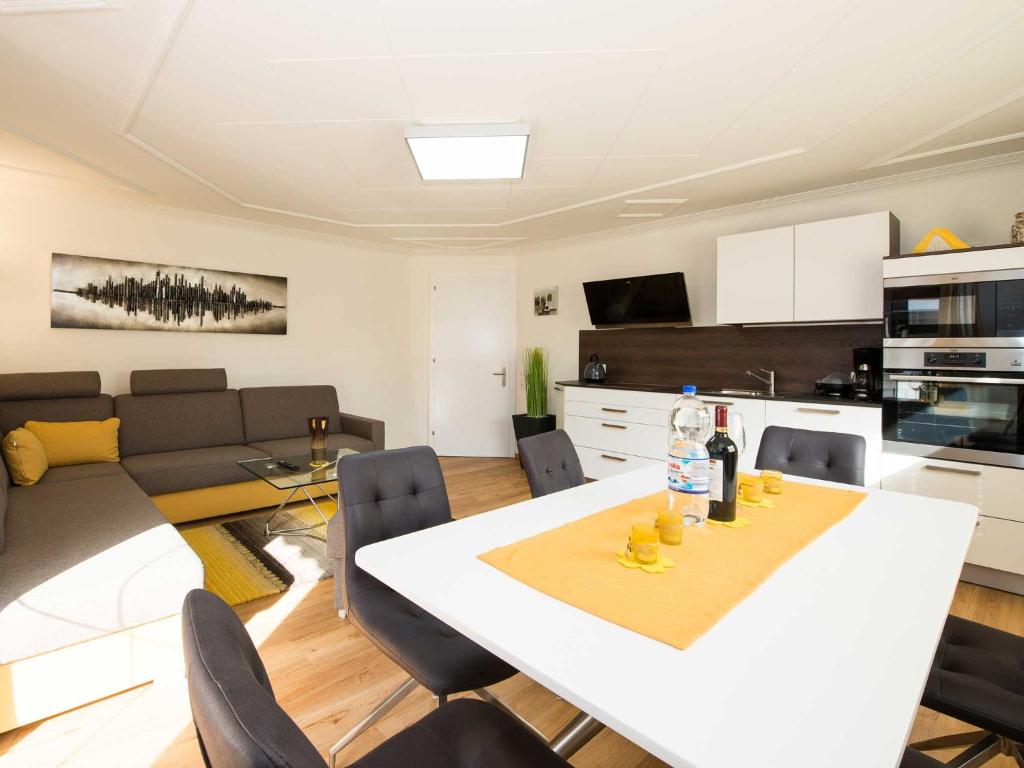 a kitchen and living room with a white table and chairs at Ferienwohnung - Bergblick - Vandans in Vandans