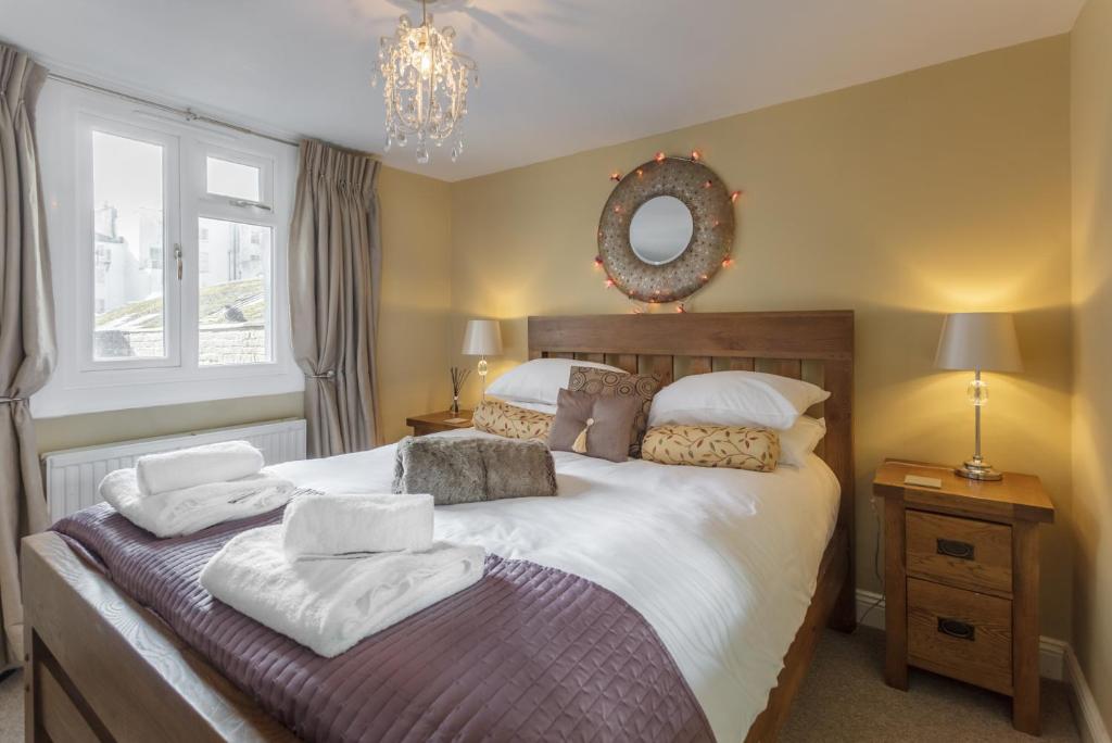 a bedroom with a bed with white sheets and a mirror at Portland Place in Brighton & Hove