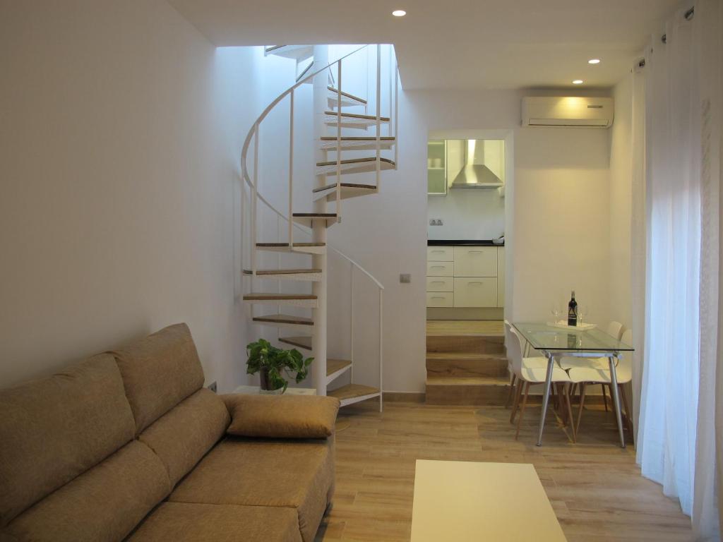 a living room with a couch and a spiral staircase at Apartamentos Romero in Alicante