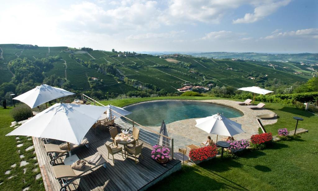 uma vista aérea de uma piscina com guarda-sóis em Albergo Castiglione Langhe em Castiglione Tinella