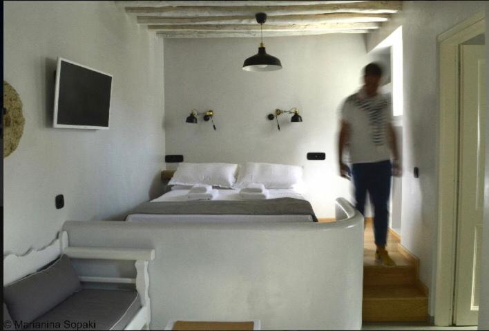 a man walking into a bedroom with a bed at Spitaki Serifos Studio in Rámos