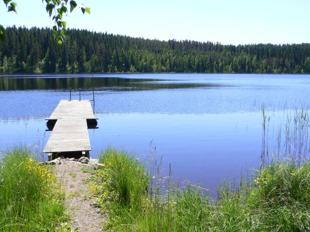 a dock in the middle of a large lake at Vanha-Pälsilä lakeside farm in Kuhmoinen