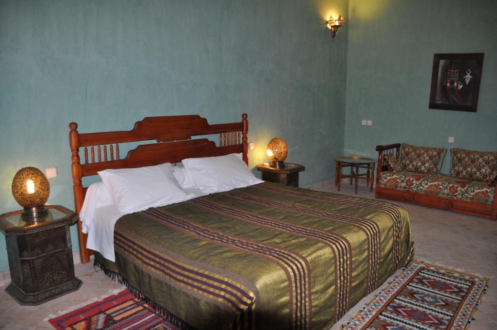 una camera con un grande letto e un divano di Hotel Kasbah Azalay a M'Hamid