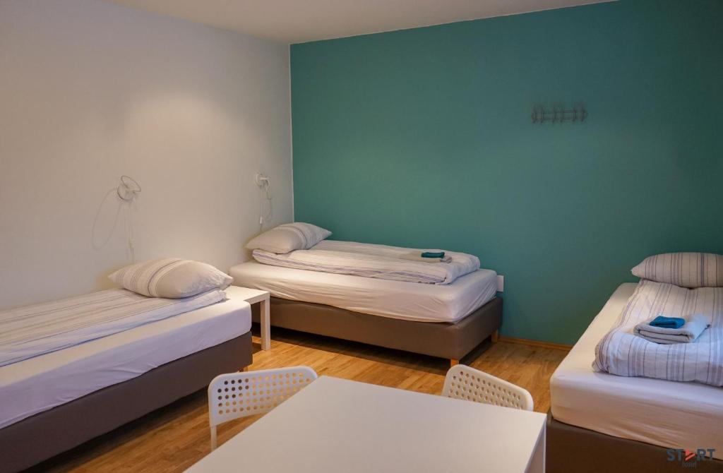 um quarto com duas camas, uma mesa e cadeiras em Start Keflavík Airport em Keflavík
