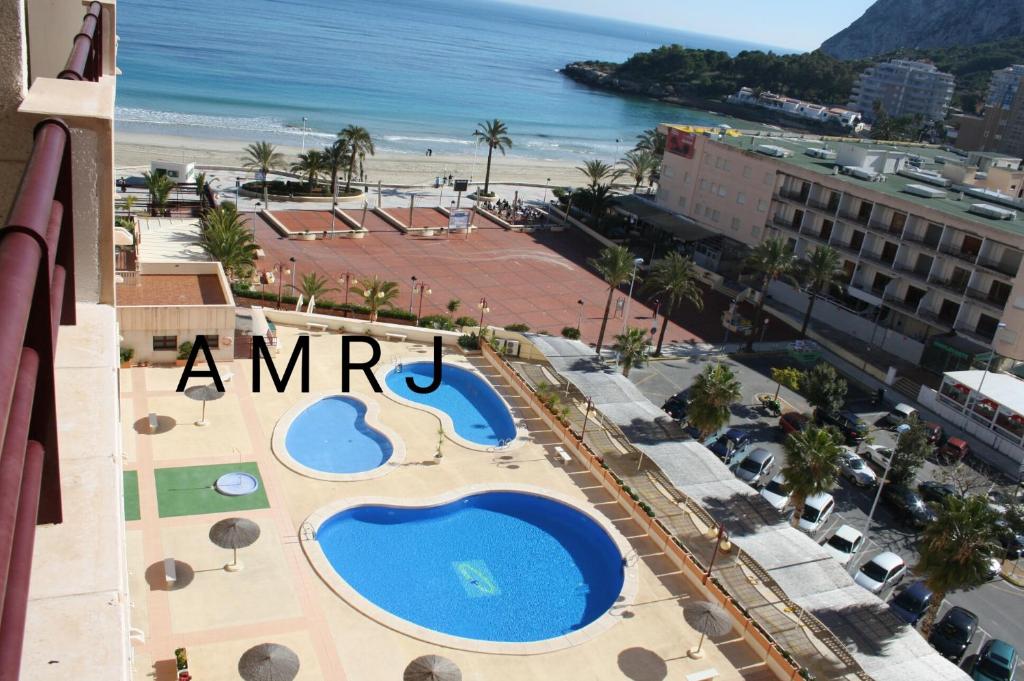 a view of a resort with two swimming pools and the beach at APTO Acceso Directo Playa La Fossa Calpe in Calpe