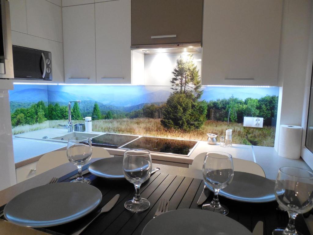 イボニチ・ズドルイにあるApartament Panoramaのテーブル(ワイングラス付)、キッチン(大きな窓付)