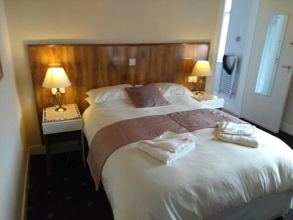 a hotel room with a bed and two lamps at Dalgair House Hotel in Callander