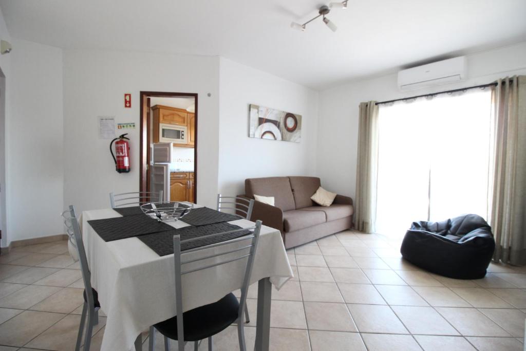 阿爾布費拉的住宿－Dinita Apartamento nº4，厨房以及带桌子和沙发的客厅。
