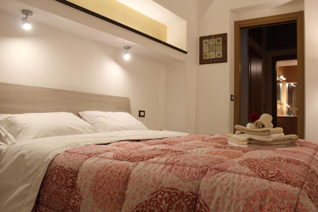 - une chambre avec un grand lit et des serviettes dans l'établissement Le Maioliche Junior Suite, à Agrigente