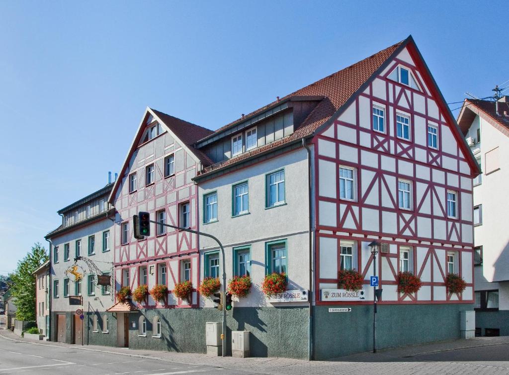 ein Gebäude mit roten und weißen Zierleisten auf einer Straße in der Unterkunft Hotel Gasthof Zum Rössle in Heilbronn