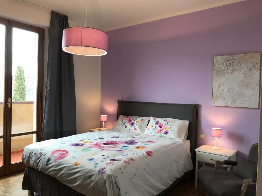 - une chambre avec un lit et un mur violet dans l'établissement La Ghirlanda B&B, à Arezzo