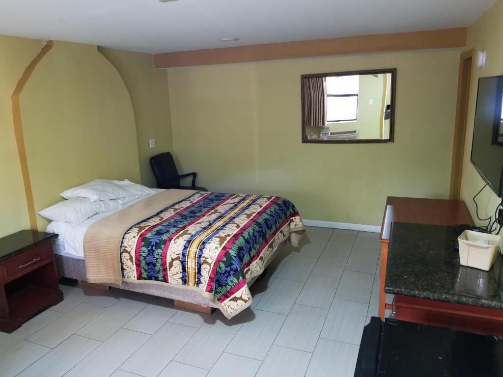 une chambre avec un lit, un bureau et une fenêtre dans l'établissement Budget Motel, à Orlando