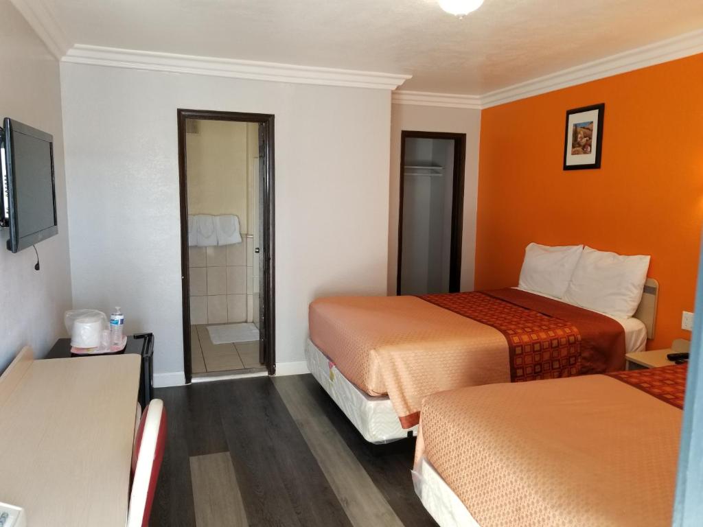 a hotel room with two beds and a shower at Value Inn Hollywood in Los Angeles