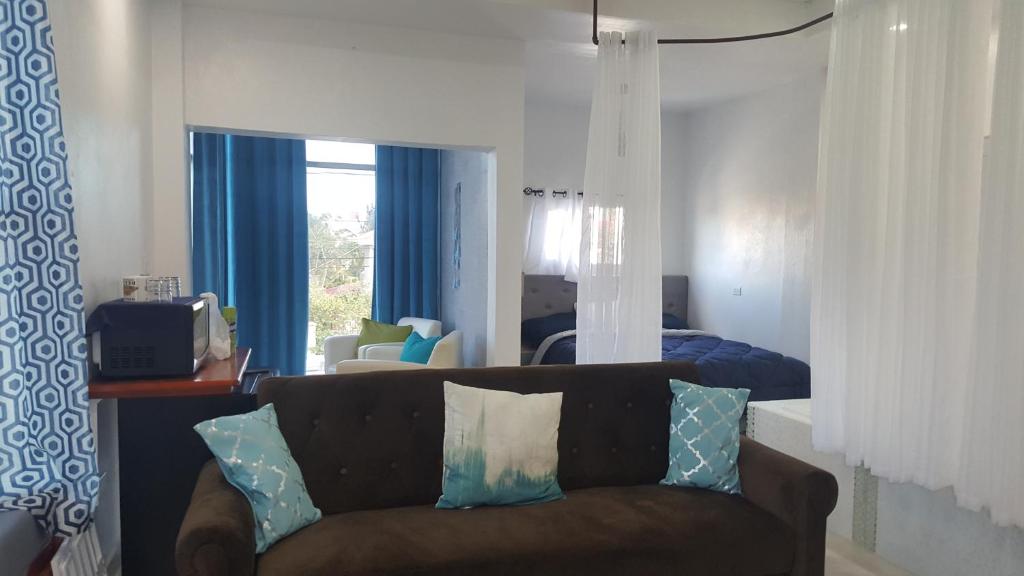 a living room with a couch and a bedroom at DB Tower Vacation Rental in Belize City
