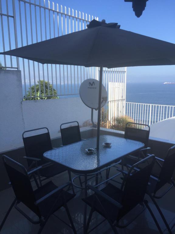 uma mesa com cadeiras e um guarda-sol numa varanda em Apartamento Quinto Sector em Viña del Mar