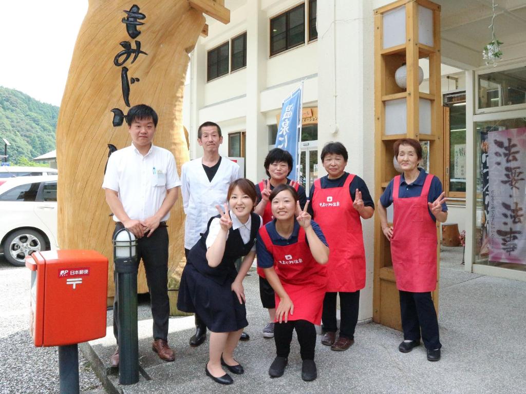 a group of people standing in front of a building at momijigawa onsen in Naka