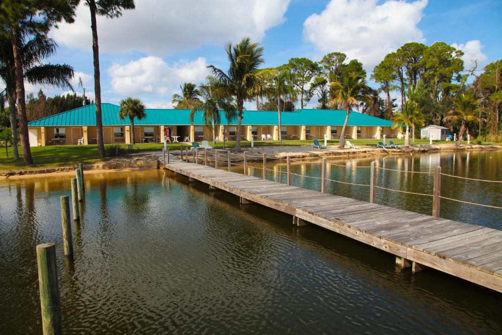 a building with a dock in front of a body of water at Lake Grassy Inn & Suites in Lake Placid