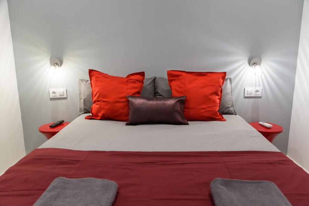 um quarto com uma cama grande e almofadas vermelhas em Fira Basic em L'Hospitalet de Llobregat