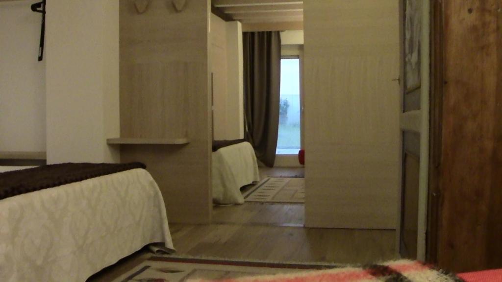 una camera con due letti e una porta per una stanza di Casa Bella a Verona