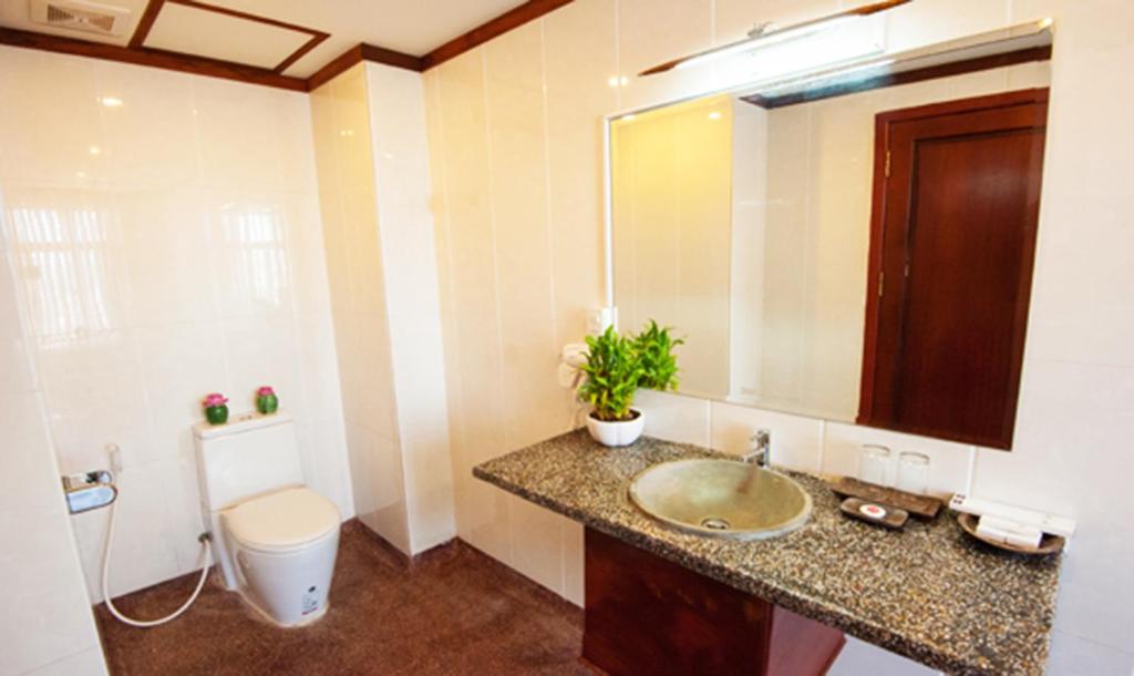 W łazience znajduje się umywalka, toaleta i lustro. w obiekcie Okay Boutique Hotel w mieście Phnom Penh