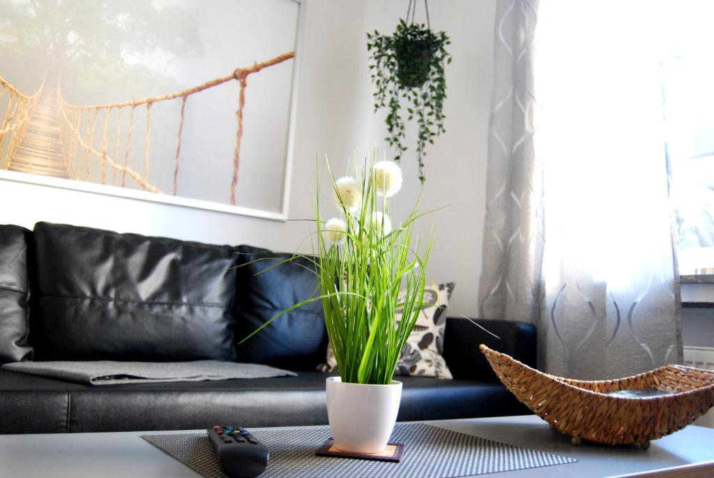 a living room with a black leather couch at Apartment Unna-Massen in Unna