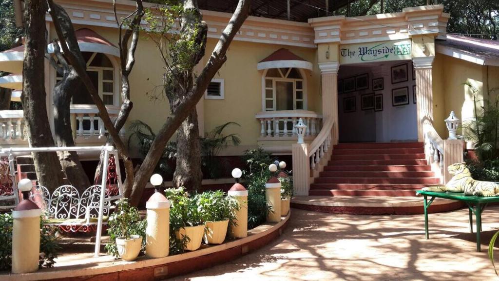 a house with a staircase in front of it at The Wayside Inn in Matheran