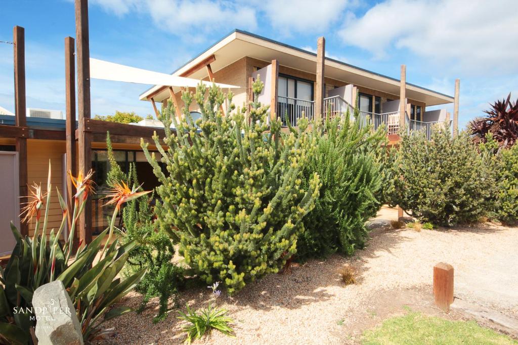 a house with plants in front of it at Sandpiper Motel Apollo Bay in Apollo Bay