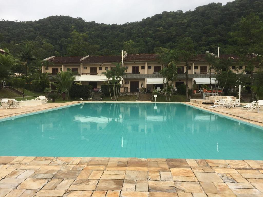 a large blue swimming pool in front of a building at Condomínio Clube lazer total na Praia da Enseada in Guarujá