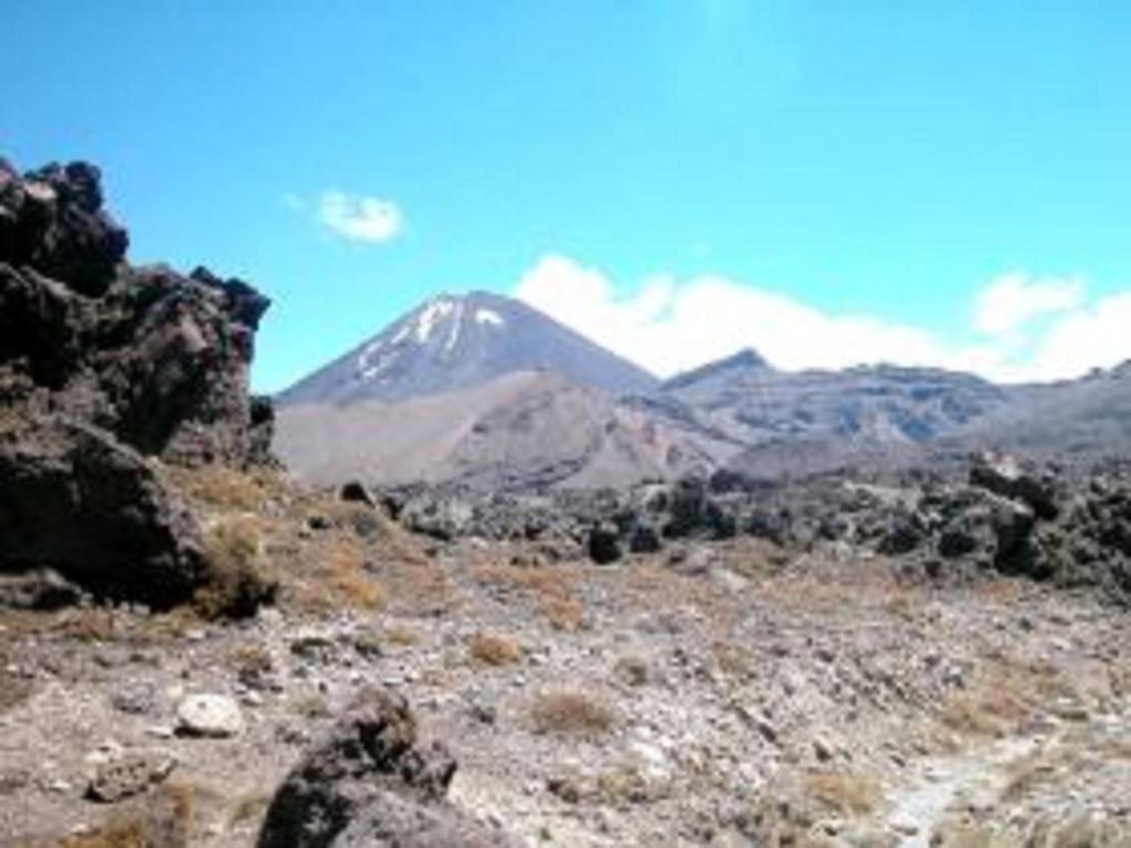 a mountain in the middle of a field with rocks at Alexander Motel in Taumarunui