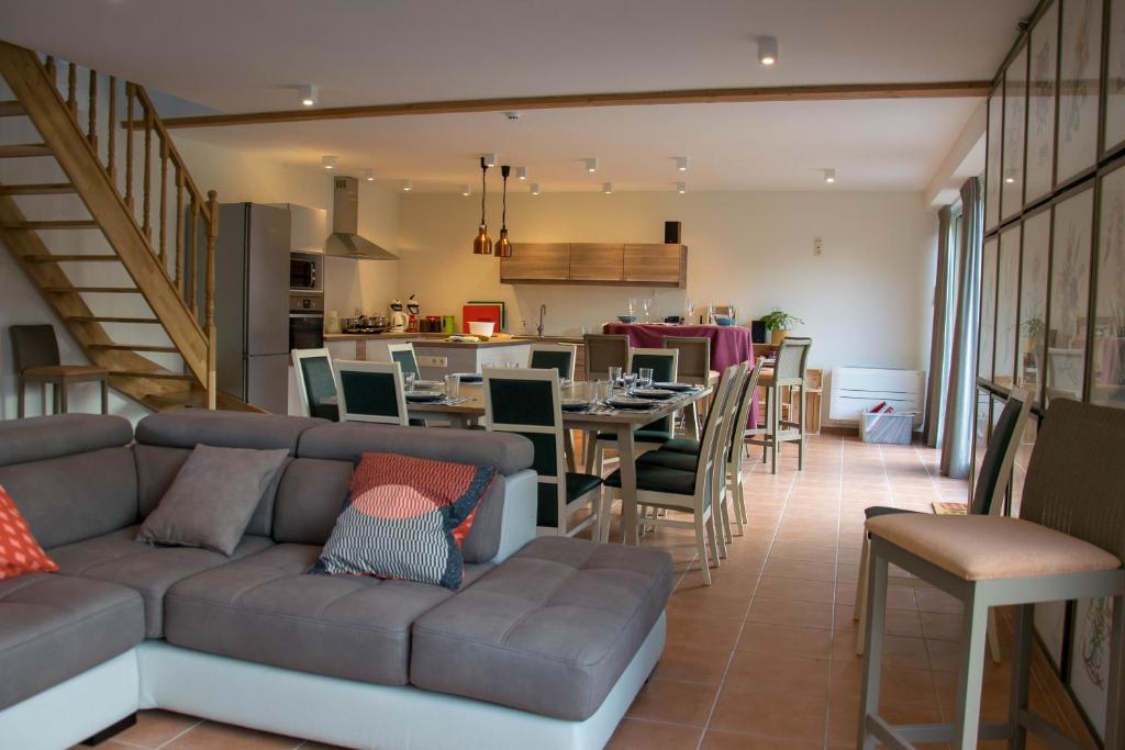 a living room with a couch and a dining room at De Prente in Heuvelland