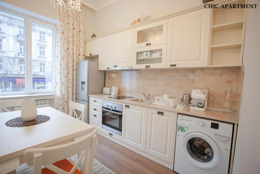 a kitchen with a washer and dryer and a table at Presidency House Self Check-in Apartments in Sofia