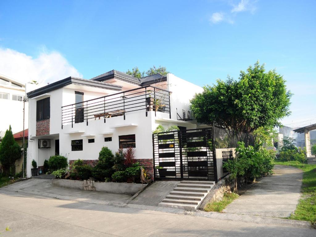 a white house with stairs in front of it at Gensan Apartment Rental in General Santos