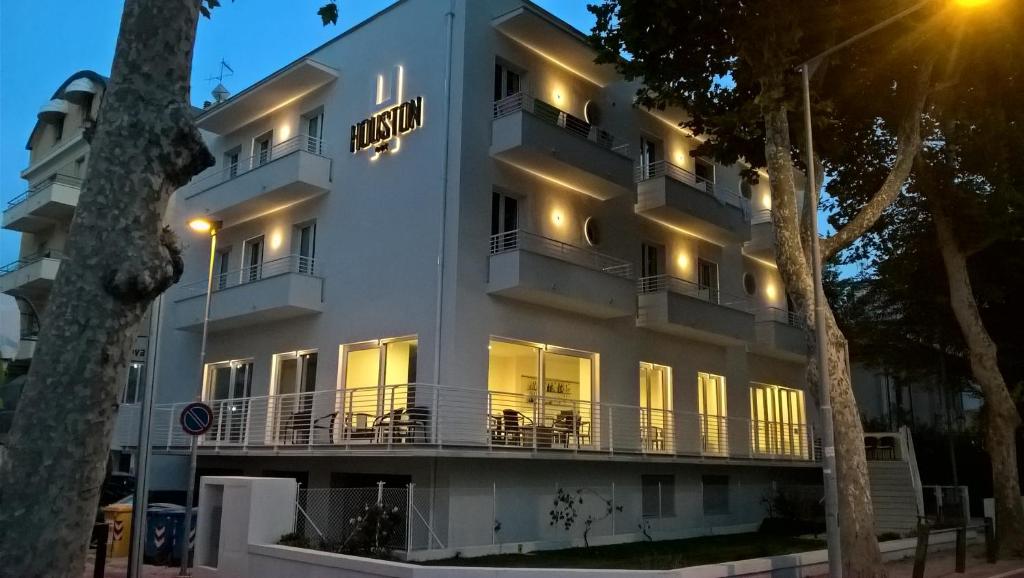 a white building with a sign on it at Hotel Houston in Rimini