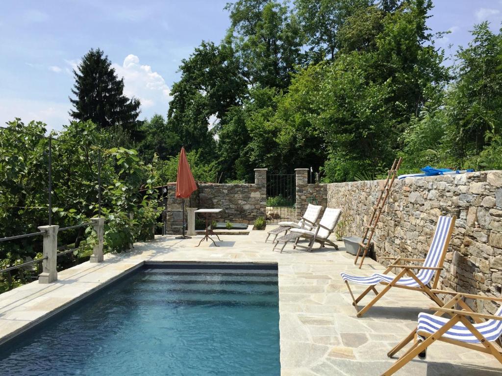 - une piscine avec 2 chaises et une table dans l'établissement Corte Villa Donati, à Cissano