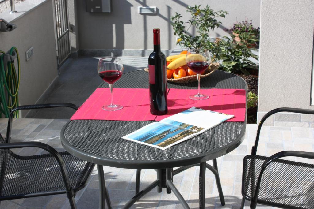 una mesa con una botella de vino y dos copas en Aurora Apartments, en Šibenik