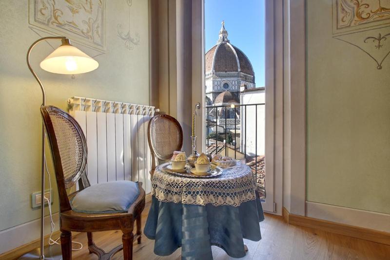 a room with a table and a view of a building at Romantic apartment in the heart of Florence in Florence