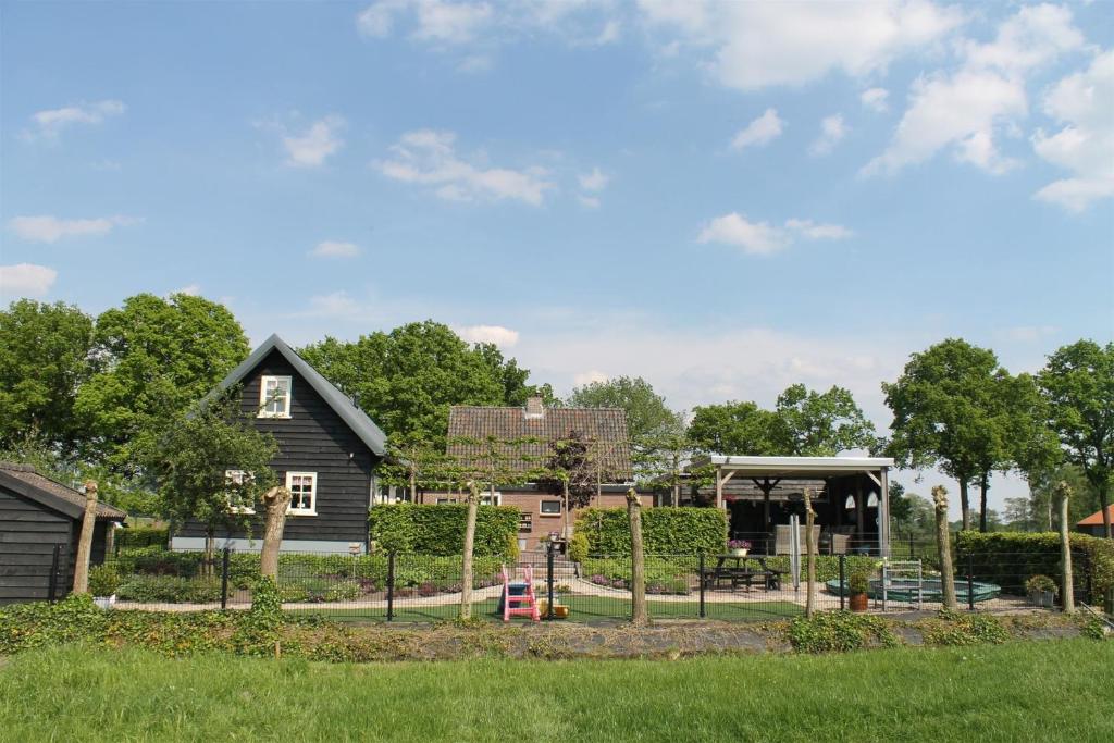 ein Haus mit einem Spielplatz vor einem Hof in der Unterkunft Guesthouse De Bongerd Overberg, B&B Holland, The Orchard in Overberg