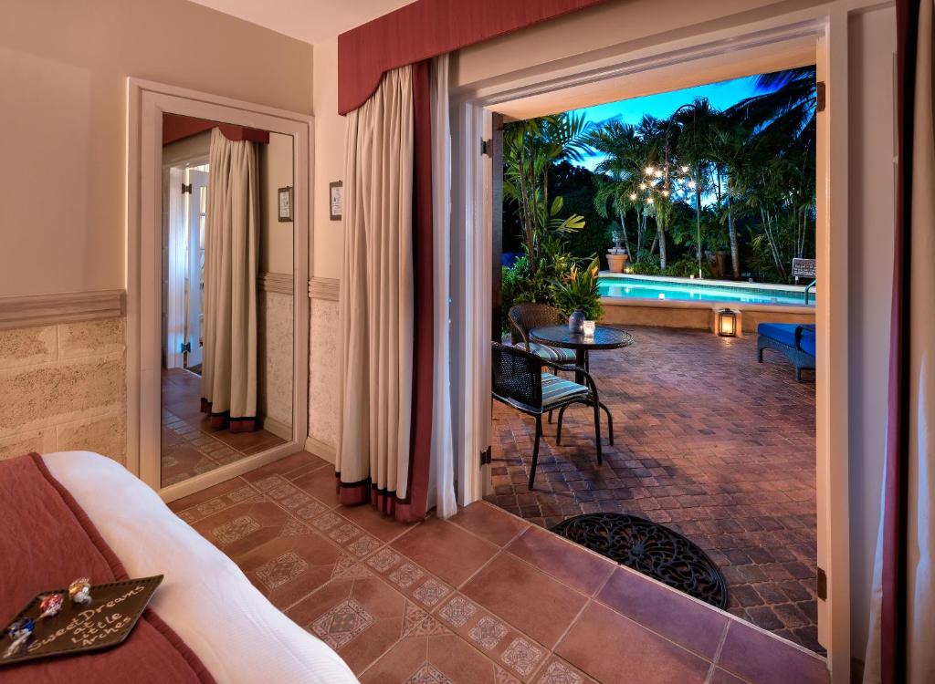 a living room with a view of a pool at Little Arches Boutique Hotel - Adults Only in Christ Church